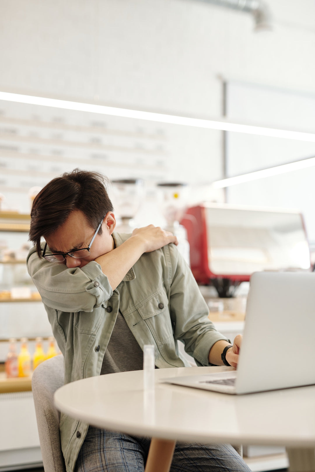 person sneezing at desk